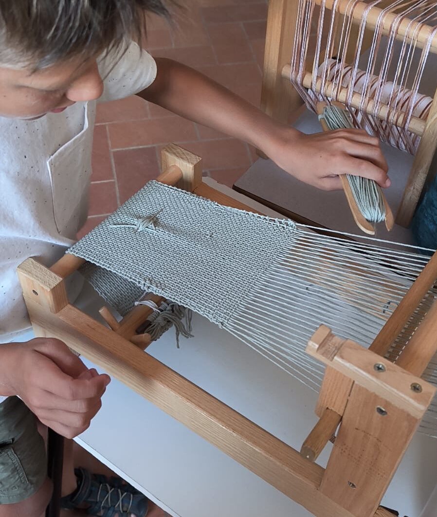 telaio a mano con una persona che tesse.